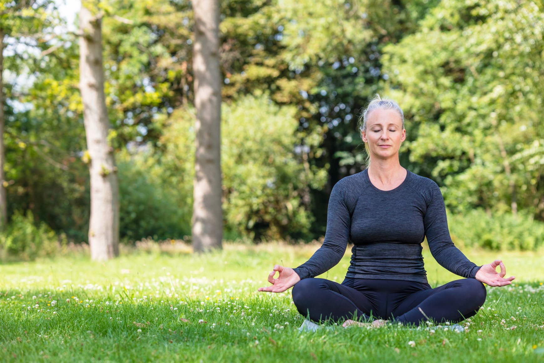  Middle- Aged Fit Woman Practicing Yoga in Nature Background